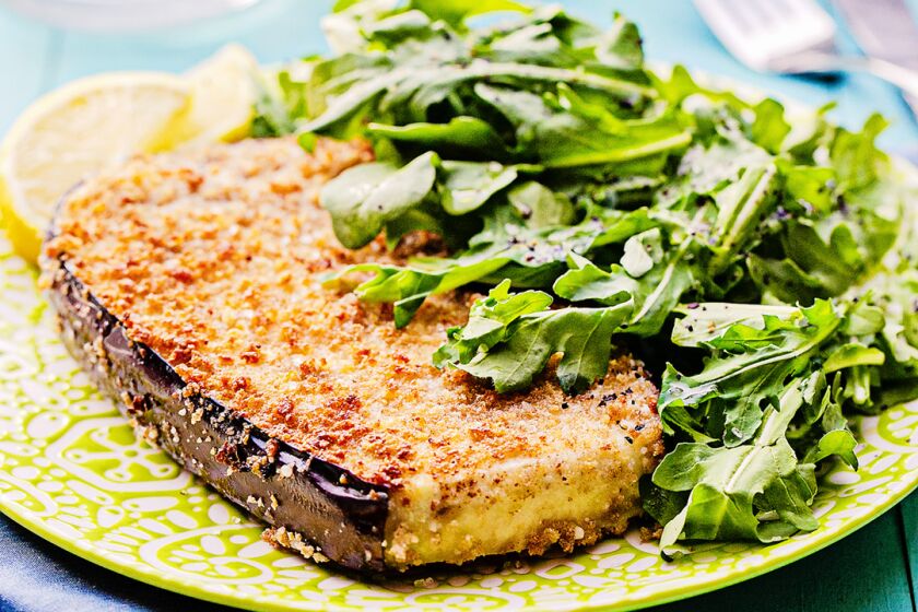 Thick-cut eggplant is breaded in cheesy panko and served with a side of fresh arugula salad.