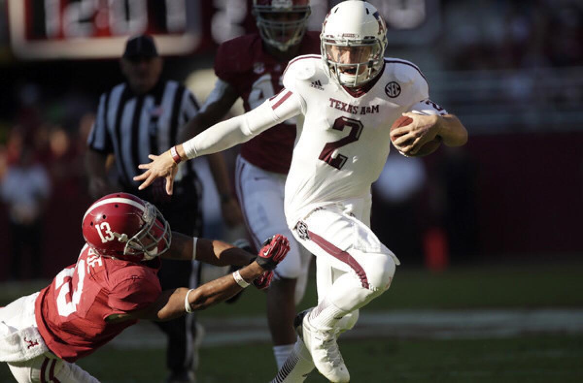 Texas A&M; quarterback Johnny Manziel (2) evades the tackle attempt of Alabama defensive back Deion Belue (13) during their game last season.