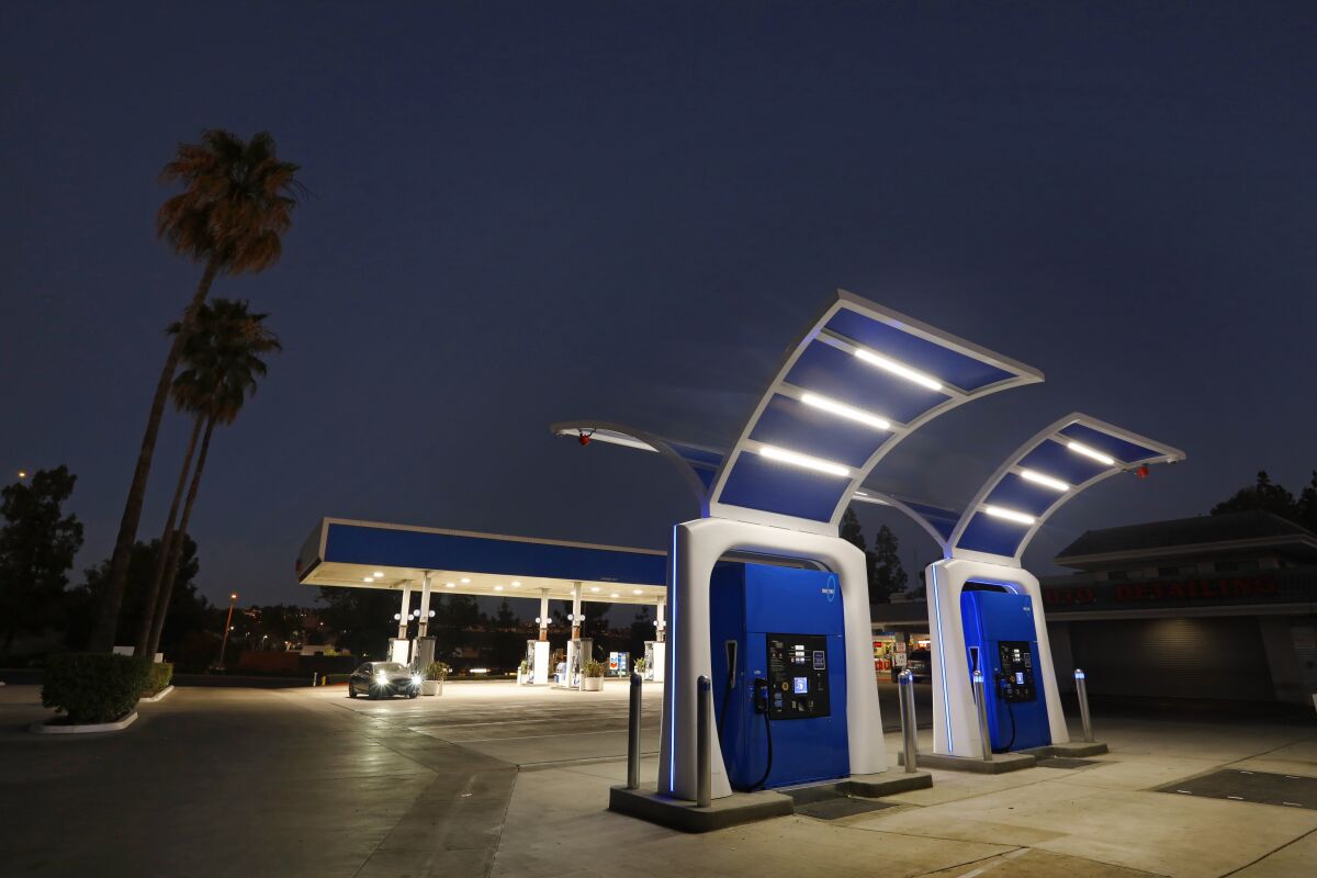 Two futuristic-looking fuel pumps are shown at a refueling station. 