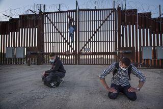 wo Cuban nationals fall to their knees in prayer moments after scaling the U.S./Mexico border fence in San Luis, Arizona