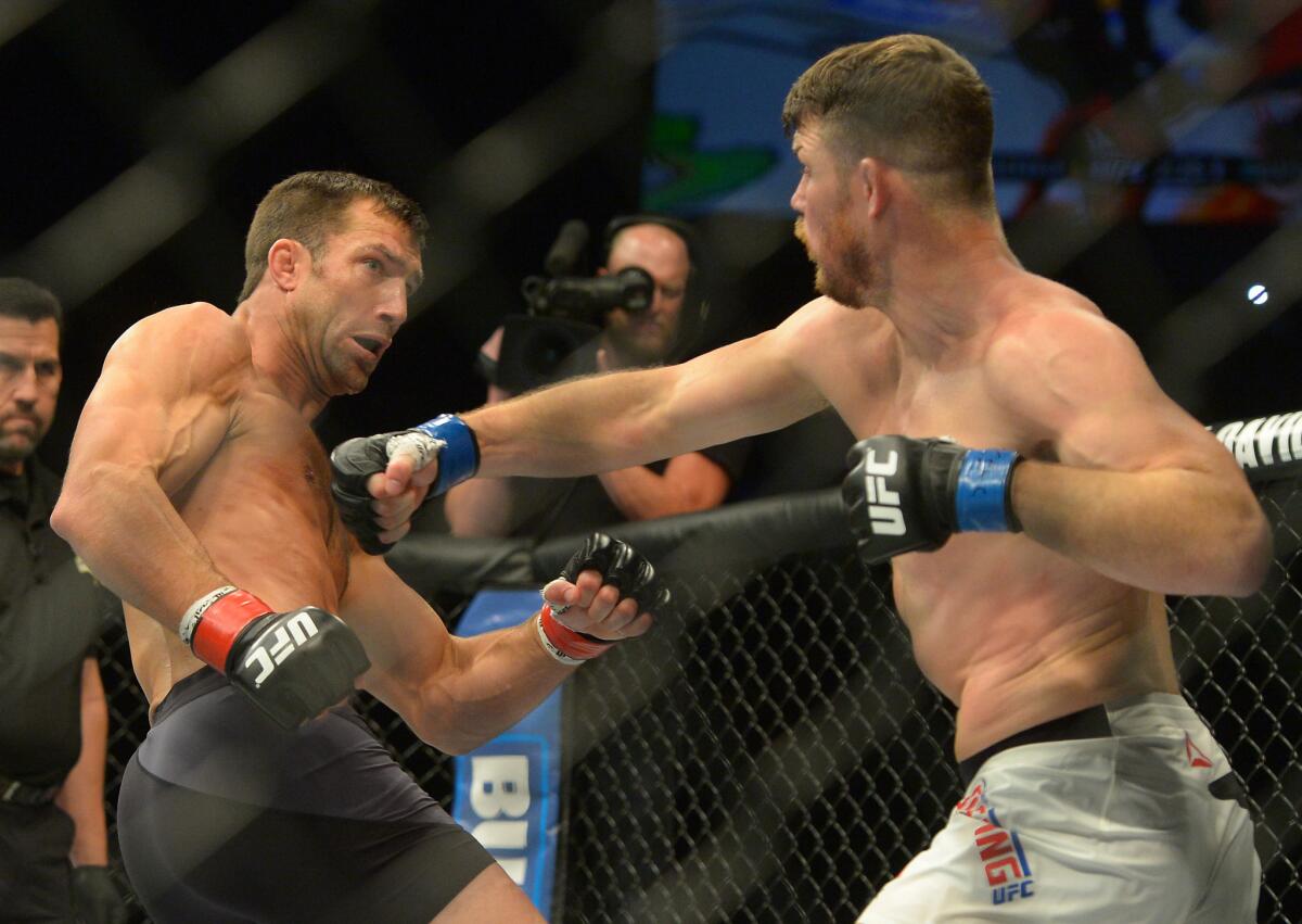 Luke Rockhold, left, tries to evade a punch by Michael Bisping during their middleweight championship bout at UFC 199.