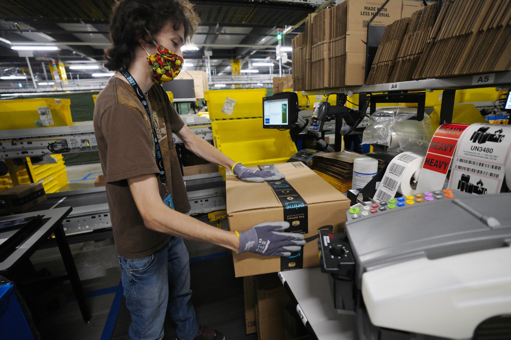 Grant Gutiérrez, empleado de Amazon, prepara el pedido de un cliente para su envío. 