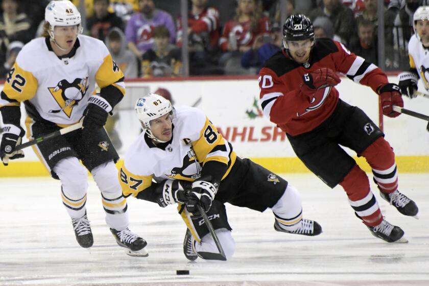 Pittsburgh Penguins center Sidney Crosby (87) reaches for the puck as New Jersey Devils center Michael McLeod.