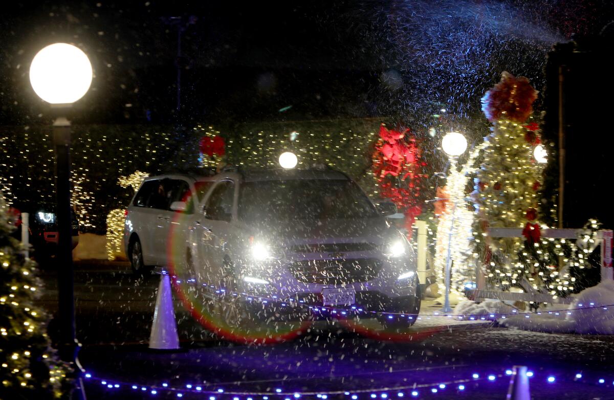 Drive-through participants pass by a snowy scene during the Night of Lights OC.