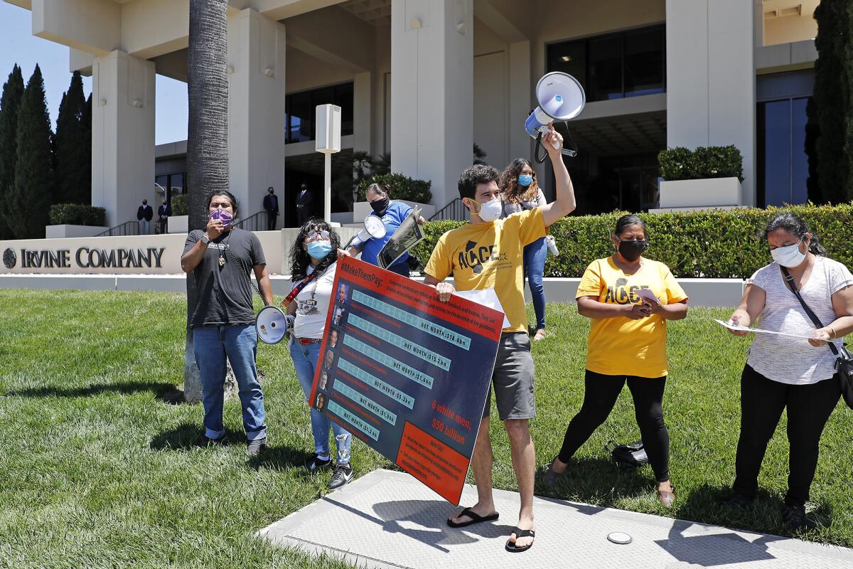 The Alliance of Californians for Community Empowerment members protest on Friday at the Irvine Co. offices in Newport Beach as part of a #MakeThemPay day of action organized by activists involved in the #CancelRent movement. The activists want federal and state lawmakers to force landlords like the Irvine Co. to stop collecting rent, mortgages and utility fees during the COVID-19 pandemic.
