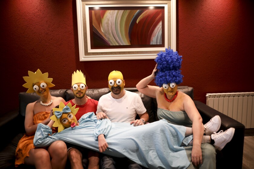 The Arevalo-Robledo family, dressed as The Simpsons, poses for a photo in their living room during a government-ordered lockdown to curb the spread of the new coronavirus in Buenos Aires, Argentina, Saturday, June 27, 2020. Mariano Arevalo is Homer, Mariel Robledo is Marge, Federico Garozzo is Bart, Julieta is Lisa and Camila Arevalo is Maggie. This family said every day of lockdown started to look the same, so they decided every Saturday to dress in different costumes to combat boredom and put some humor into their lives. (AP Photo/Natacha Pisarenko)