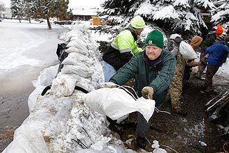 New snow added to the difficulty as the Red River continued to rise in Fargo, N.D.