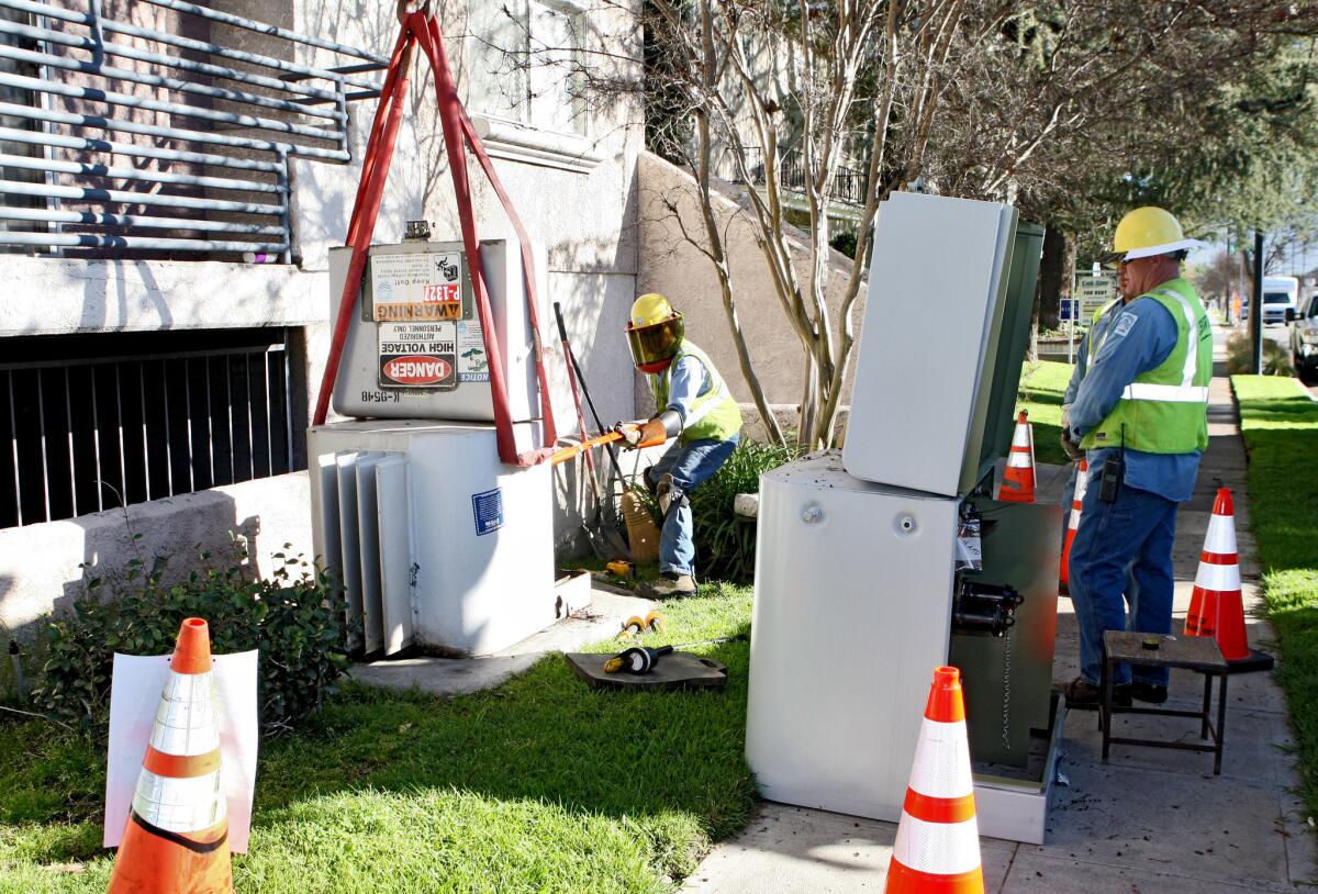 Burbank Water & Power electrical line mechanic Christopher Vilchis, left, unplugs an old transformer as a new one is ready for replacement at 600 N. Whitnall in Burbank on Thursday, Feb. 12, 2015. Foreman Kirk Jensen is at right.