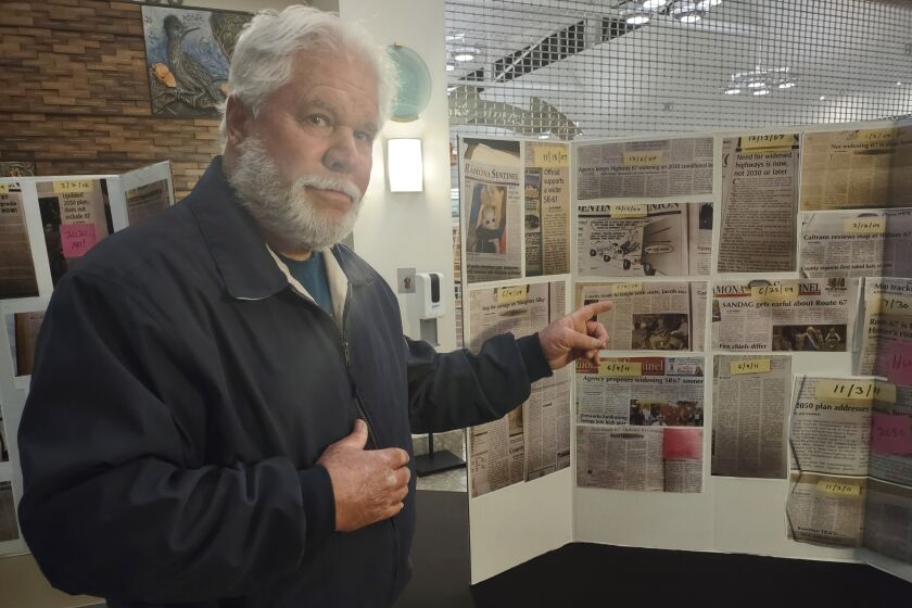Ramona Community Planning Group member Dan Summers points to newspaper articles related to SR-67 widening.