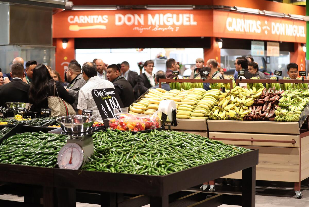 Guests gather around the produce floor during the grand opening of Mercado González.