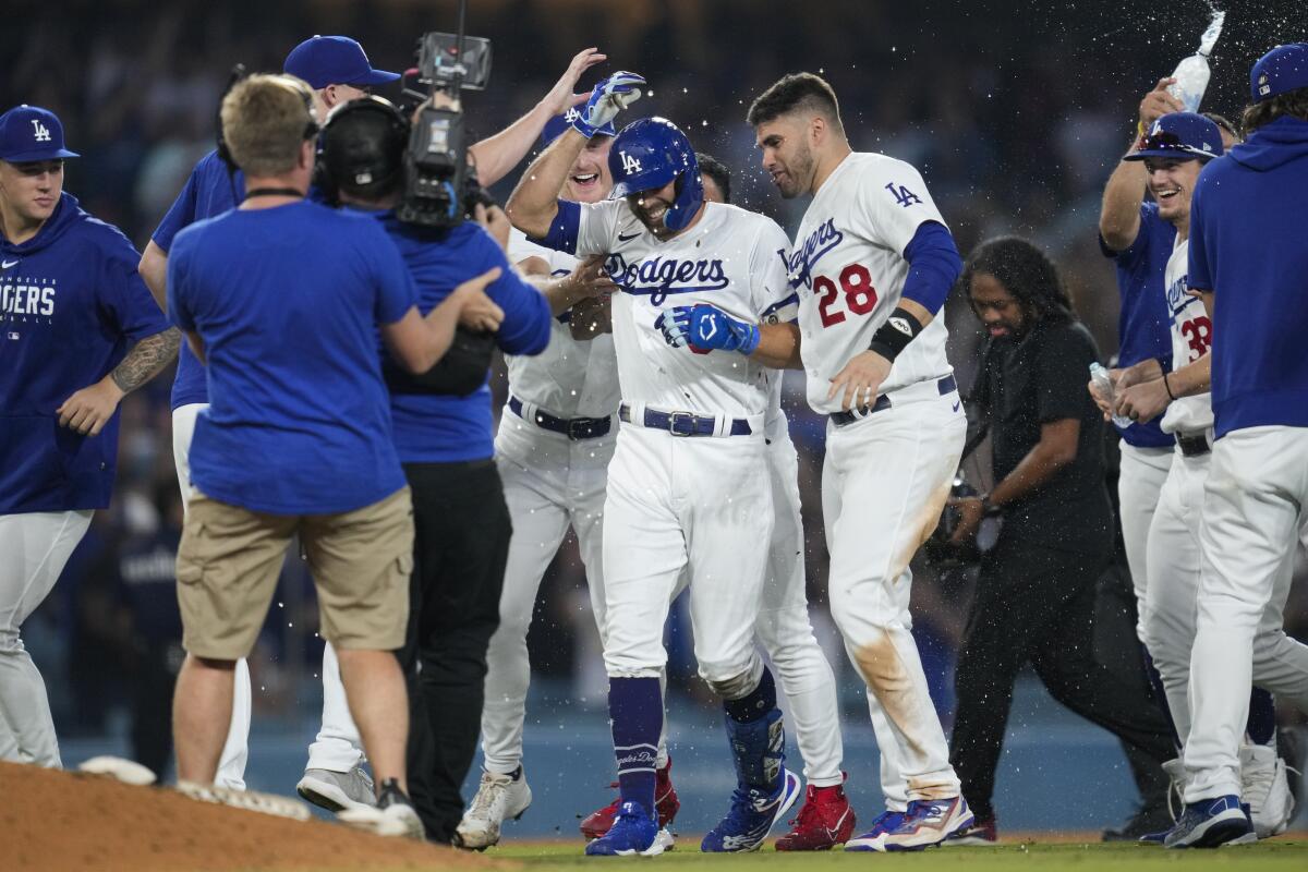 Chris Taylor, center, celebrates with teammates after hitting a walk-off single against the Giants at Dodger Stadium.