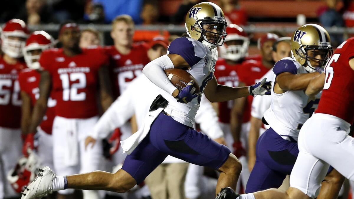 Washington's Dante Pettis follows a blocker as he returns a punt for a touchdown against the Rutgers during the second quarter Friday.