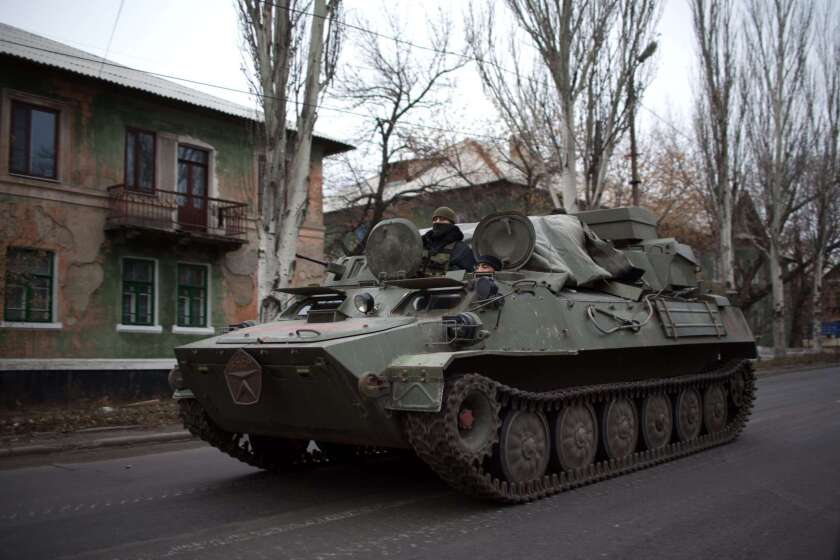 An armored personnel carrier rolls on a main road in rebel territory near the village of Torez in eastern Ukraine. 