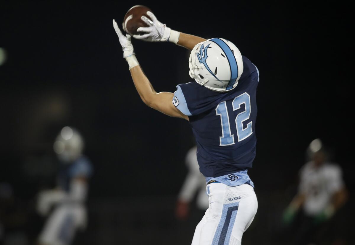 Corona del Mar's Simon Hall catches an 87-yard touchdown pass from Ethan Garbers in the first half of a season opener against Downey on Friday at Newport Harbor High.