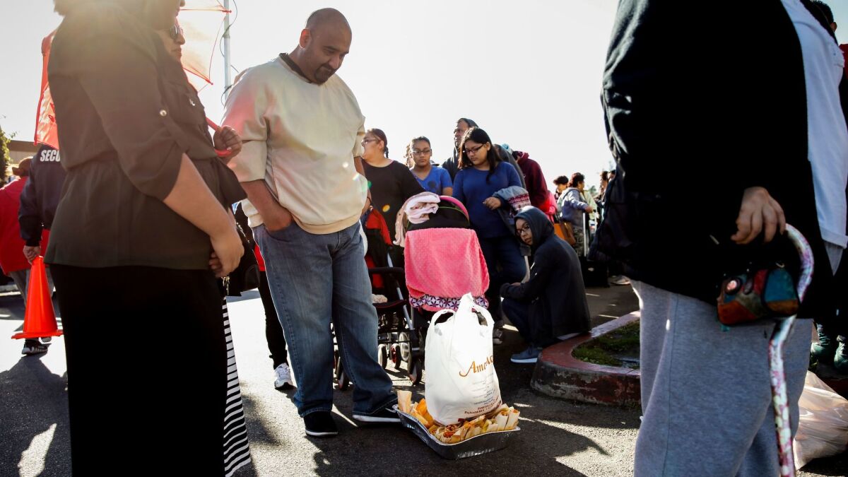 John Cardenas of Whittier pushes a pan of bad tamales and a bag of bad masa along the ground while waiting in line for a refund outside Amapola Deli and Market last year.