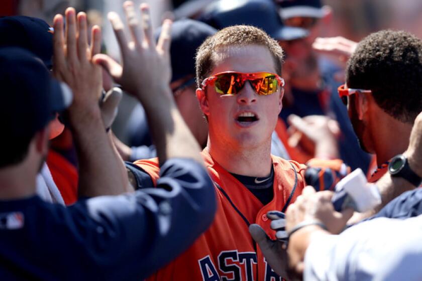 Astros third baseman Matt Dominguez is congratulated by teammates in the dugout after hitting a three-run home run against the Angels in the seventh inning Sunday at Angel Stadium.