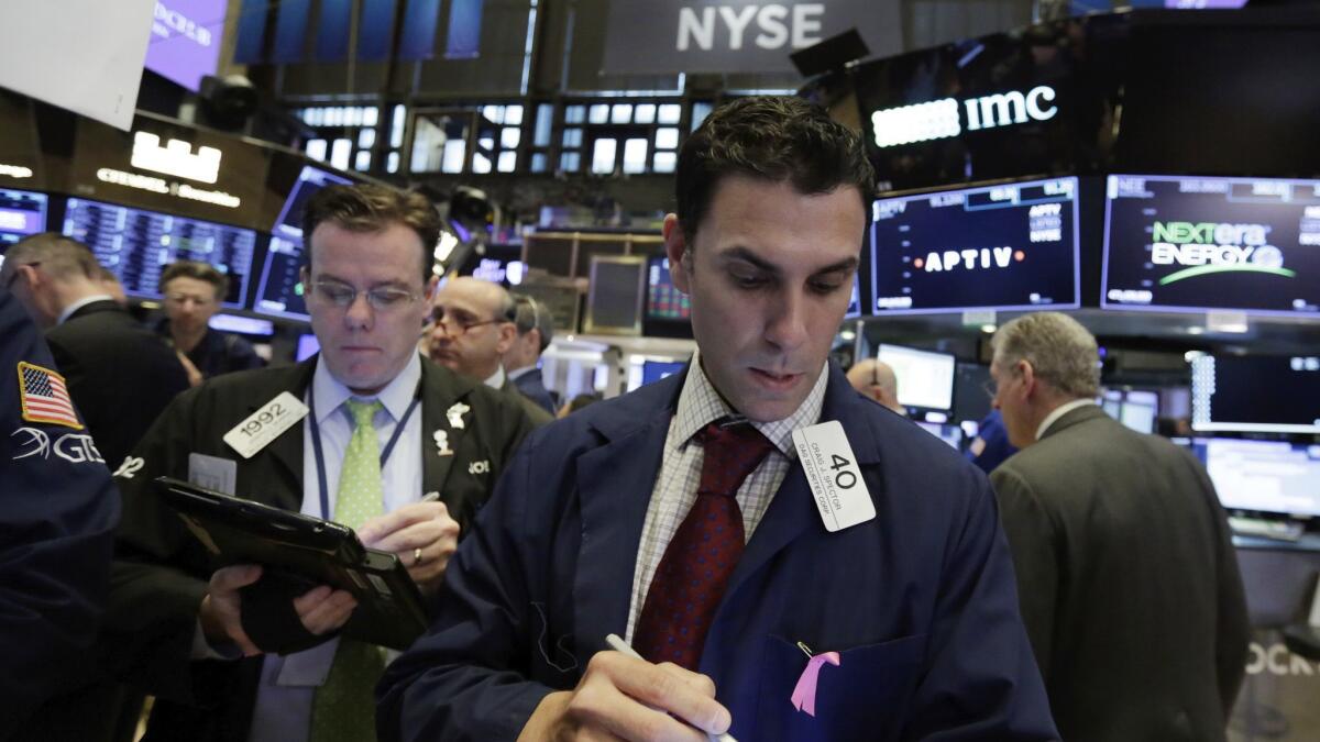 Trader Craig Spector, center, works on the floor of the New York Stock Exchange.