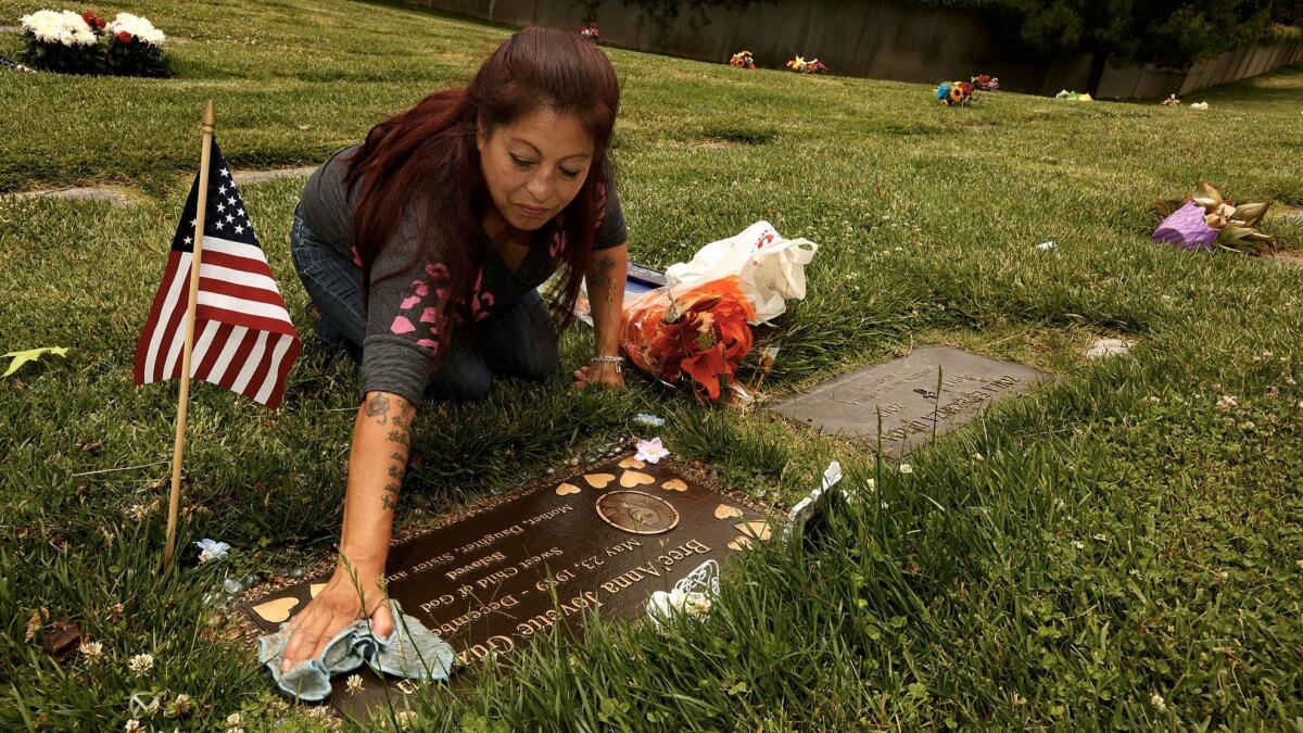 Darlene Guzman cleans her daughter Bree'Anna Jovette Guzman's gravesite at Forest Lawn Memorial Park in Glendale. (Genaro Molina / Los Angeles Times)