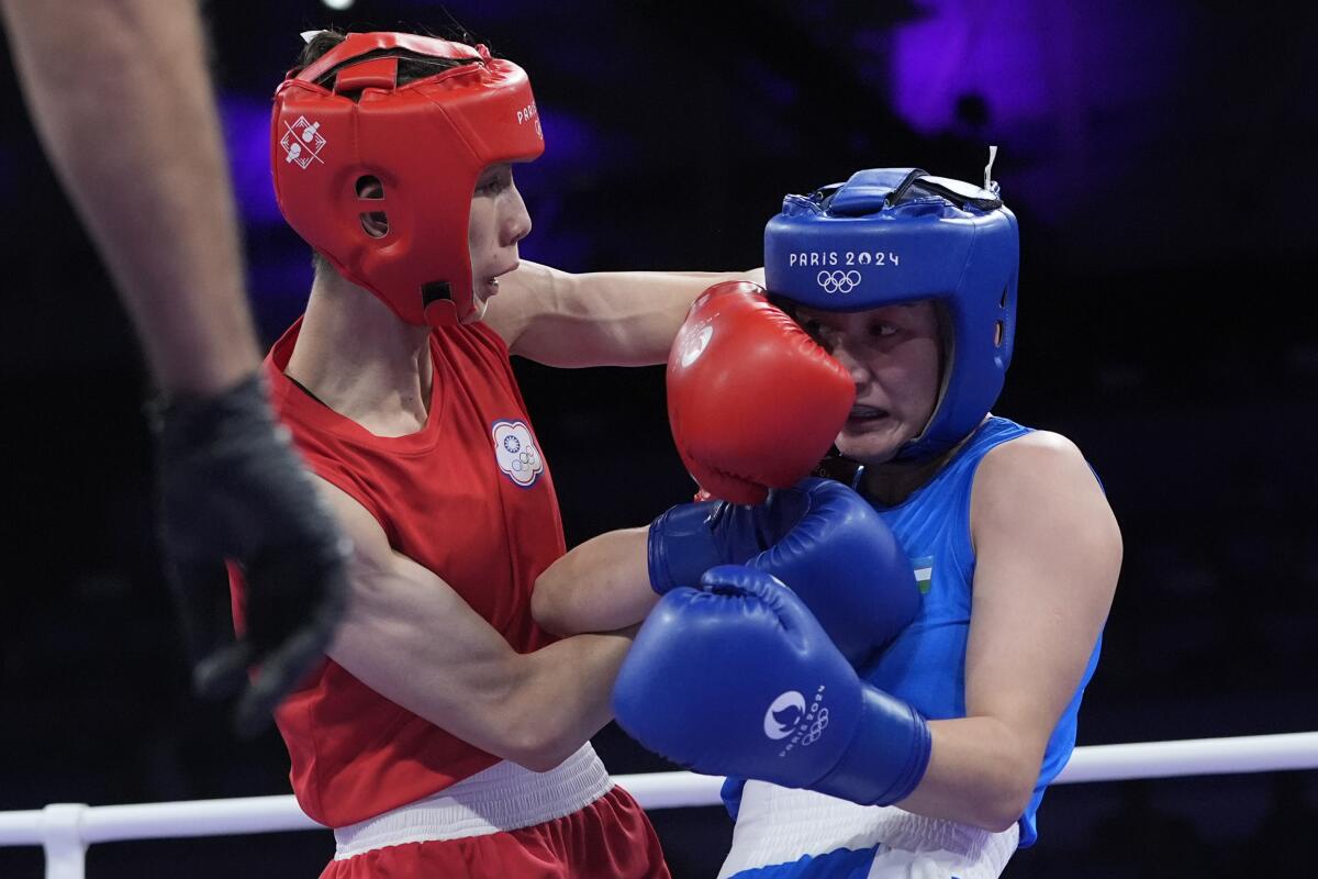 Taiwan's Lin Yu Ting, left, fights Uzbekistan's Sitora Turdibekova during a women's 57-kilogram preliminary round match.