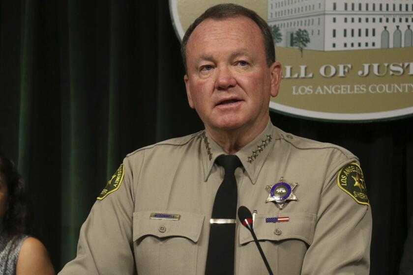 Los Angeles County Sheriff Jim McDonnell comments on the release of a sketch of a man of interest in an unsolved killing that occurred in 2005, that was developed by investigators re-interviewing people previously questioned in the investigation of the fatal shooting of 27-year-old Edward Berber, during a news conference in Los Angeles Tuesday, July 17, 2018. Investigators say Berber, the father of two was living alone and nothing was stolen from his home. Investigators are seeking the public's help in solving the killing. At left is the victim's sister, Alejandra Johnson. (AP Photo/Ariel Tu)