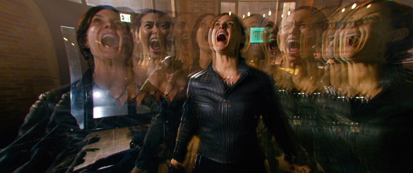 A woman is shown screaming in multiple overlapping images in a scene from "The Matrix Resurrections."