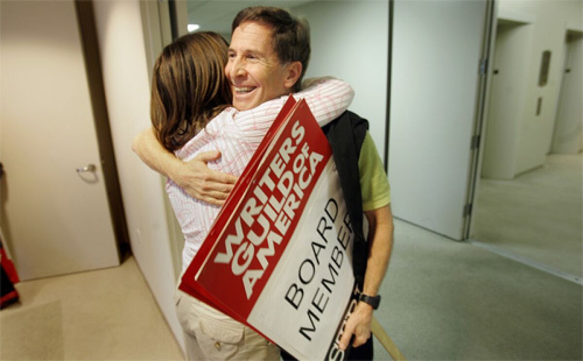 END IN SIGHT: Board members Robin Schiff, left and Tom Schulman embrace moments before a press conference announcing the potential end to the WGA strike.