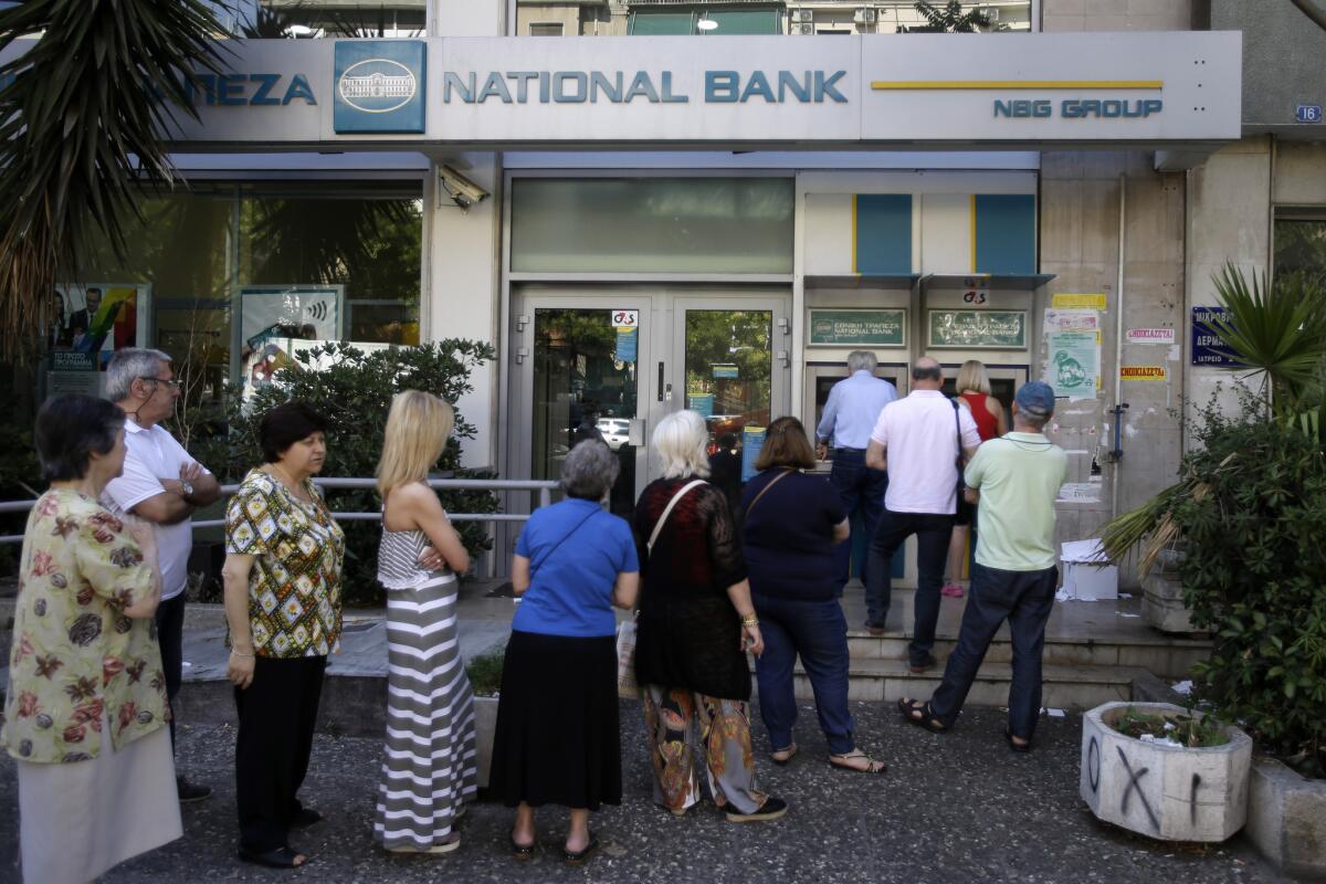People line up at an ATM in Athens next to a closed bank. In London, a crowdfunding campaign called the "Greek Bailout Fund" has been launched on Indiegogo.