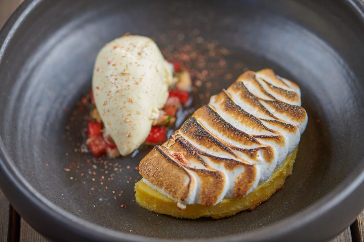Elote Dulce at El Jardín Cantina is a delicious sweet corn pudding cake topped with a corn husk meringue, charred cob ice cream and a strawberry salsa. 
