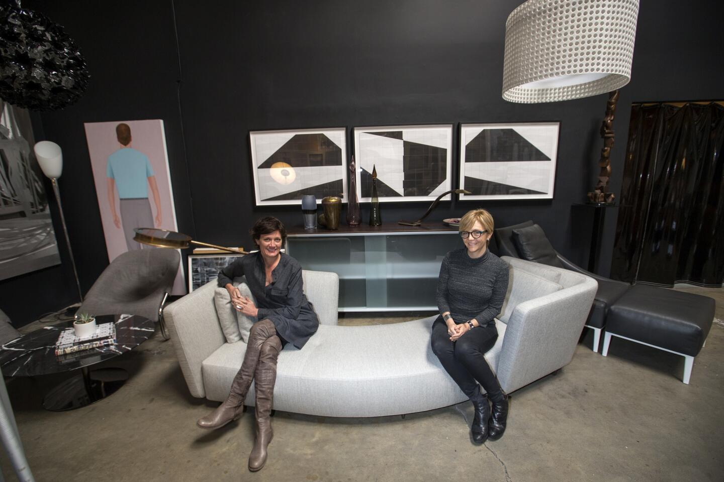 Stacia Vinar, left, and Sarah Whipple, owners of Modern Resale, sit among some of the modern European furniture, lighting and accessories at their Los Angeles showroom. The pieces are secondhand but inspected for quality.