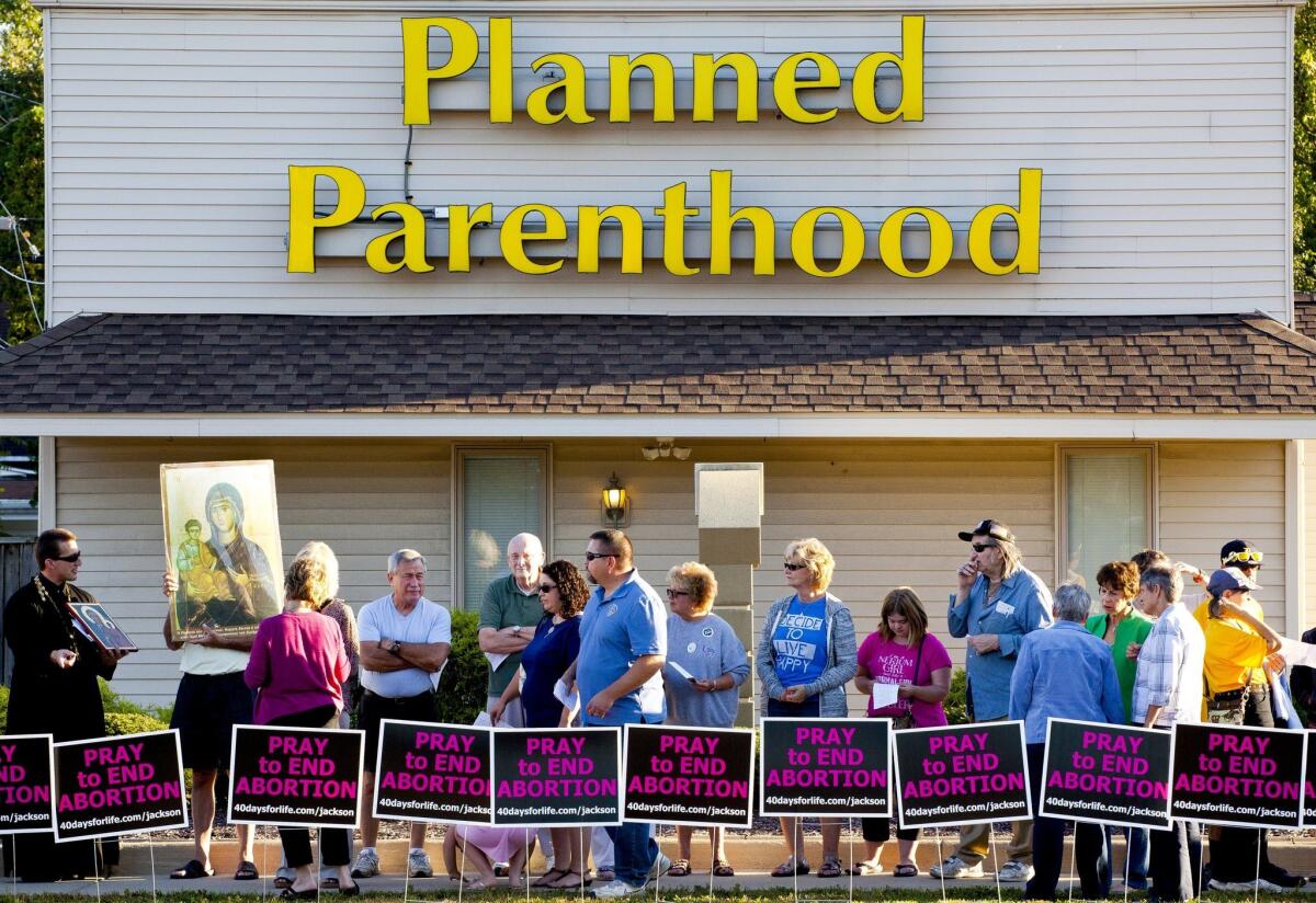 People protest outside of Planned Parenthood on Wednesday in Jackson, Mich. Participants sang and prayed to end abortion and close Planned Parenthood.