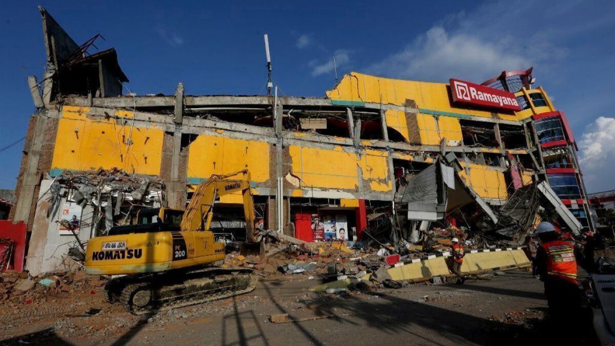 An excavator is used to search for victims in the damaged Ramayana shopping mall after a massive earthquake and tsunami in Palu, Indonesia.