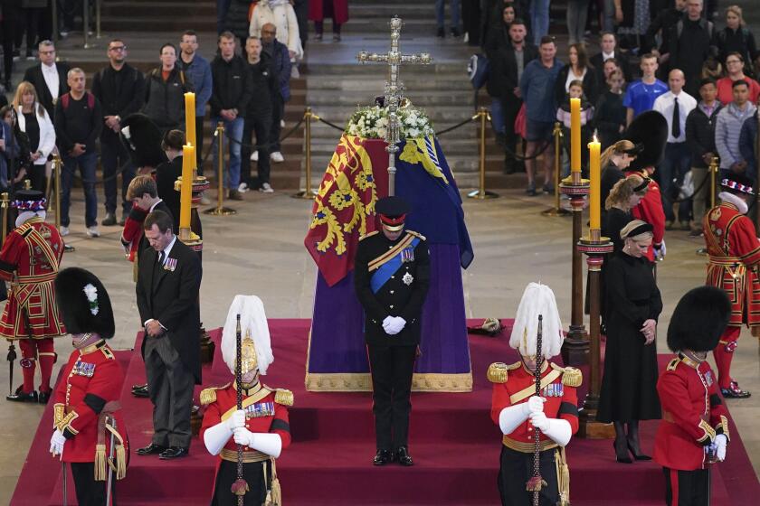 CAPTION CORRECTS BYLINE Queen Elizabeth II 's grandchildren, clockwise from front centre, Prince William, the Prince of Wales, Peter Phillips, James, Viscount Severn, Princess Eugenie, Prince Harry, the Duke of Sussex, Princess Beatrice, Lady Louise Windsor and Zara Tindall bow, during the vigil of the Queen's grandchildren, as they stand by the coffin of Queen Elizabeth II, as it lies in state, in Westminster Hall, at the Palace of Westminster, London, Saturday, Sept. 17, 2022, ahead of her funeral on Monday. (Yui Mok/Pool Photo via AP)