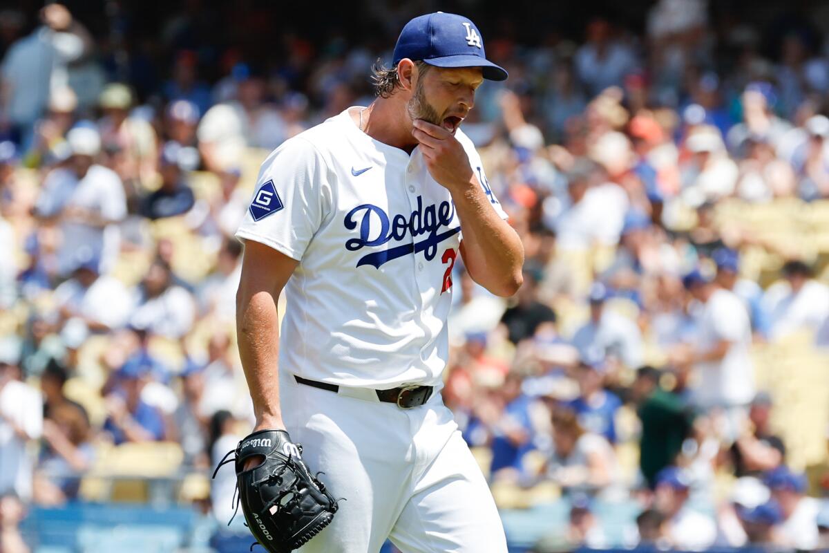 Dodgers starter Clayton Kershaw rubs his chin on the mound during a home game