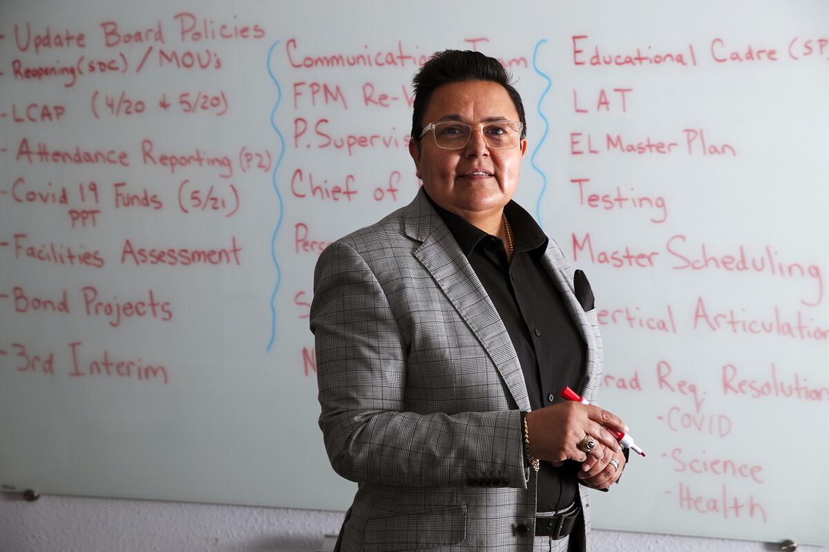 A person stands in front of a whiteboard full of writings.