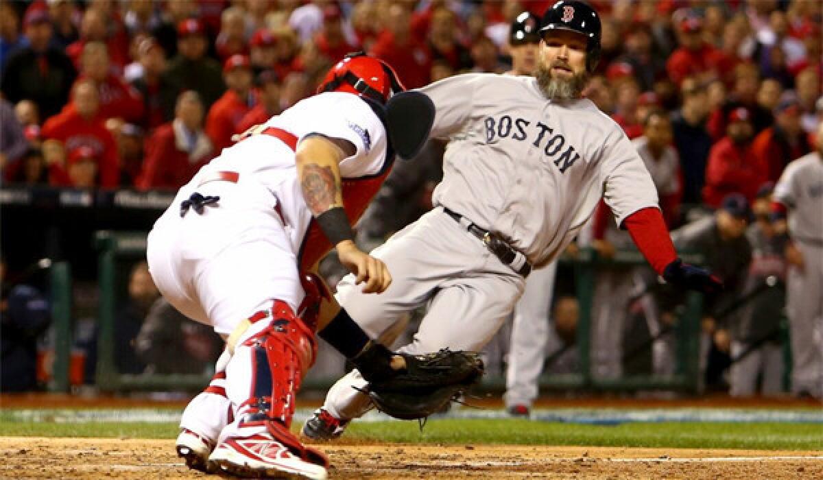 Cardinals catcher Yadier Molina, who won his sixth consecutive Gold Glove award Tuesday, tags out Red Sox catcher David Ross in Game 5 of the World Series at the plate. Boston defeated St. Louis, 3-1, to take a three games to two lead in the series.