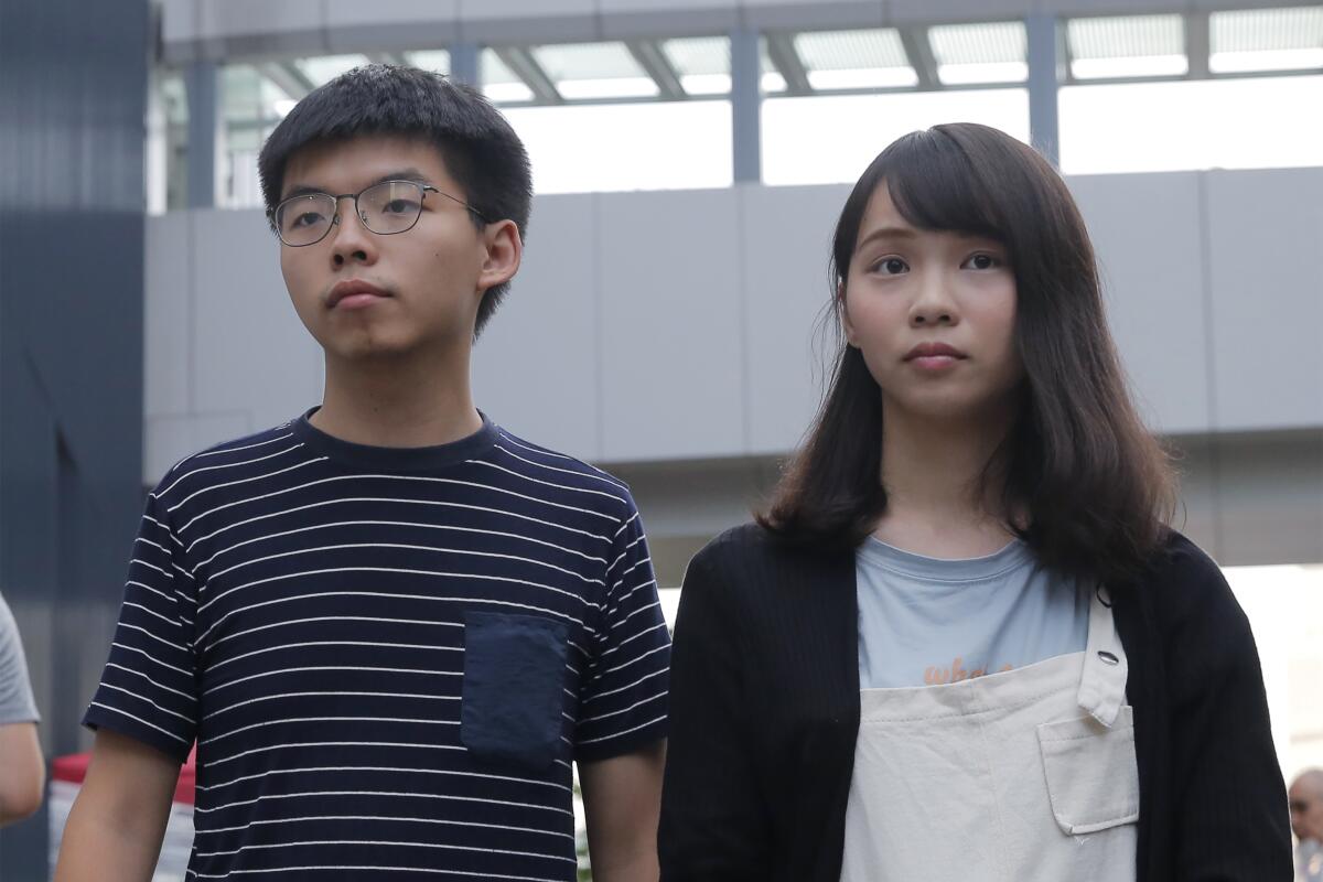 Pro-democracy activists Joshua Wong and Agnes Chow meet media outside a government office in Hong Kong in June