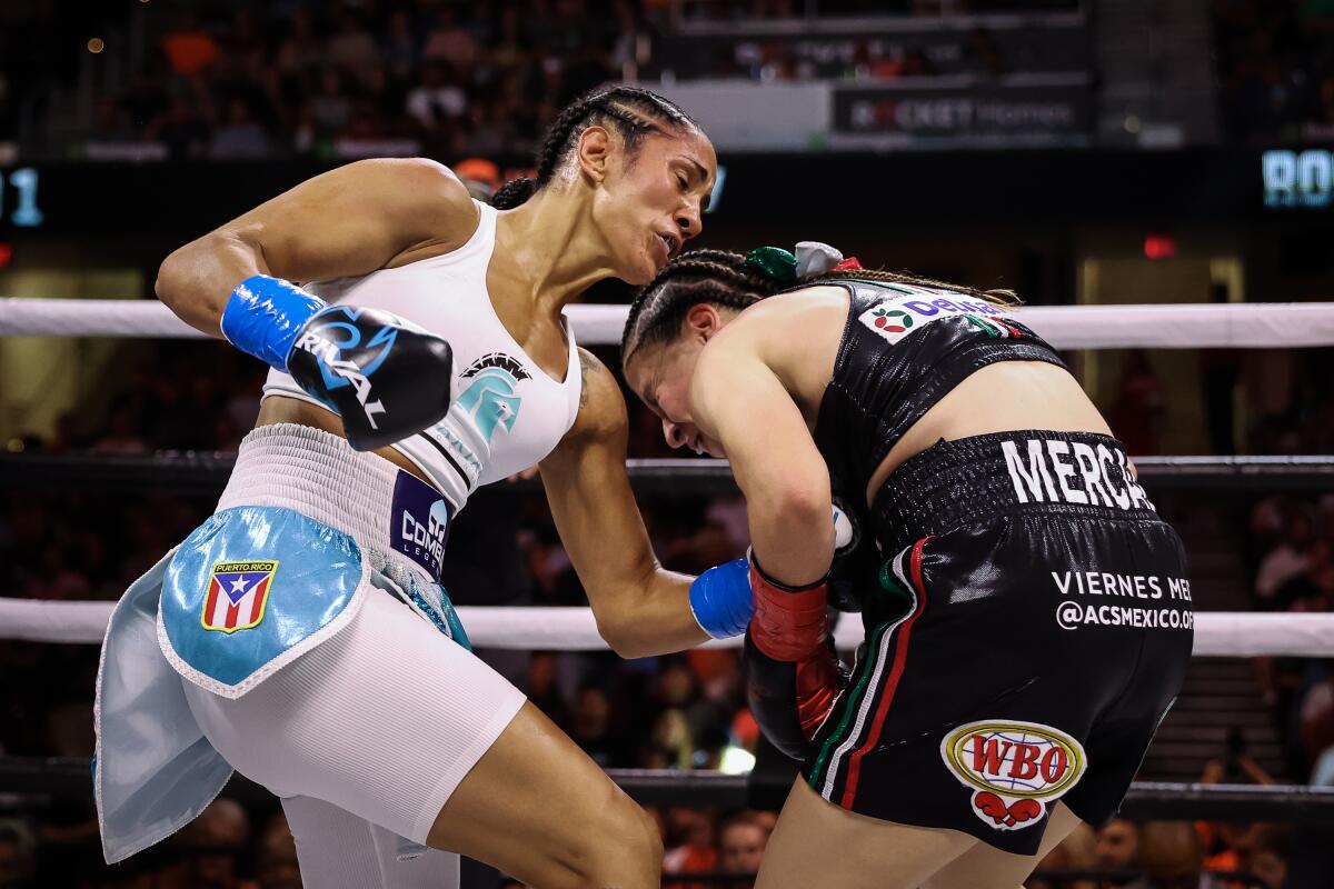 Seven-division world champion Amanda Serrano punches Yamileth Mercado during their boxing match Sunday.