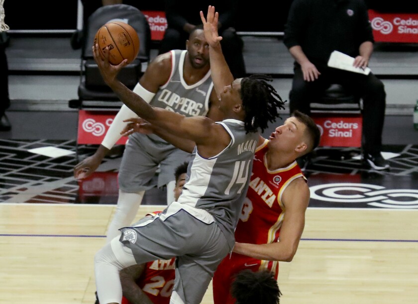 Clippers guard Terance Mann drives and scores against Atlanta Hawks guard Bogdan Bogdanovic during a game on March 22.