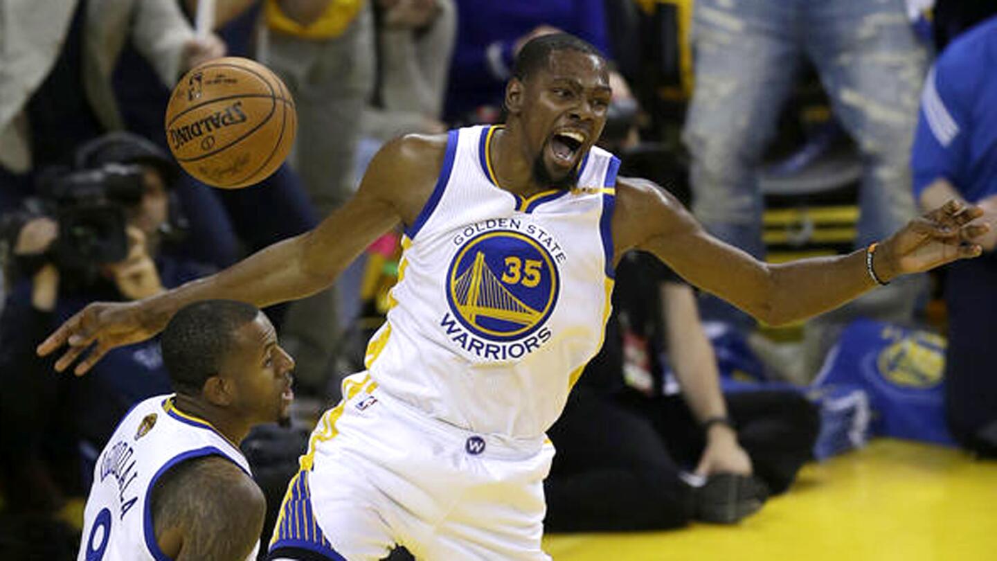 Warriors forward Kevin Durant (35) and teammate Andre Iguodala react after Durant made an alley-oop dunk against the Cavaliers during the first half.