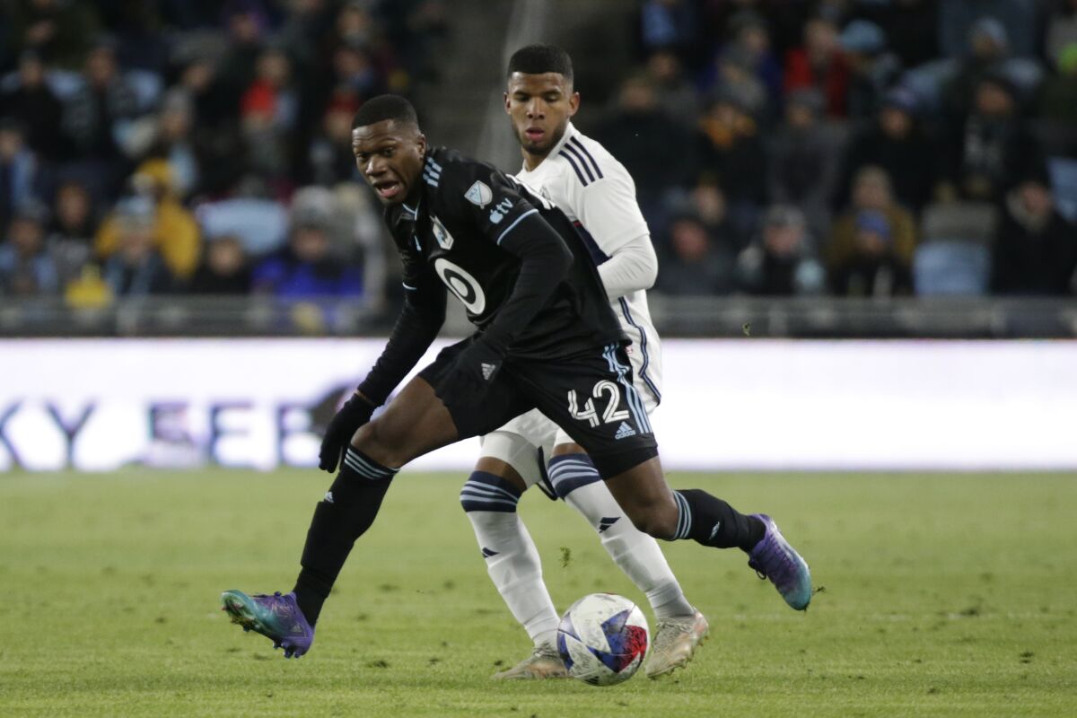 Minnesota United Emmanuel Iwe controls the ball in front of Vancouver Whitecaps midfielder Pedro Vite (45) in the second half of an MLS soccer game Saturday, March 25, 2023, in St. Paul, Minn. (AP Photo/Andy Clayton-King)