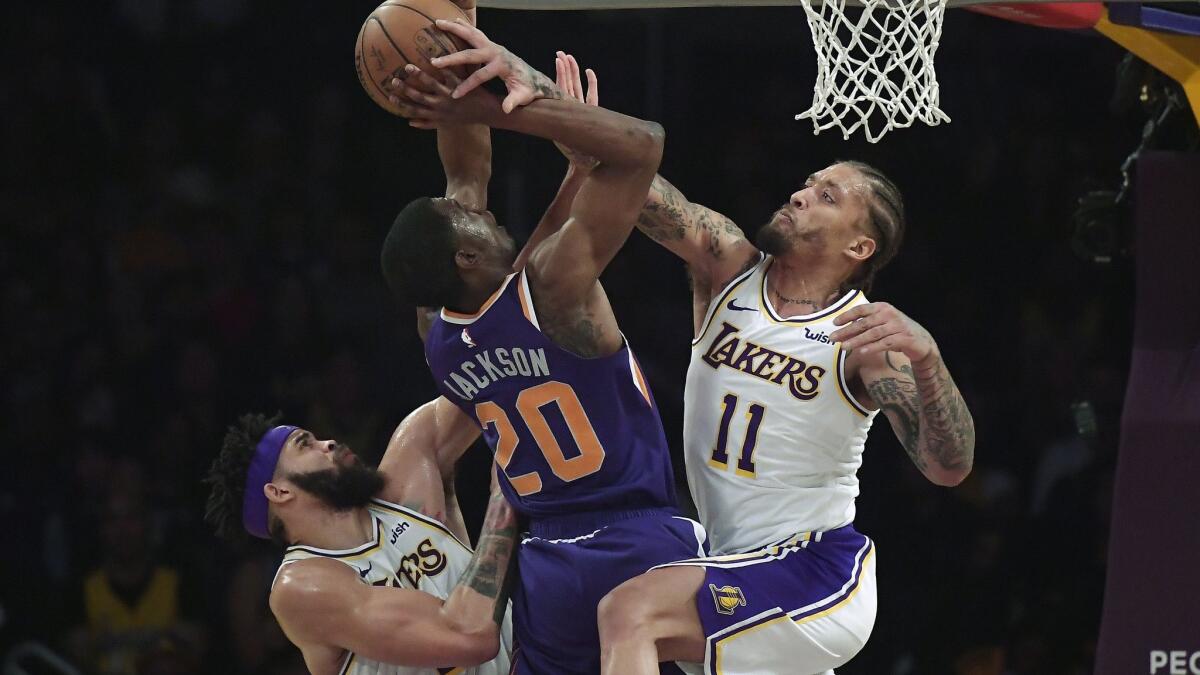 Phoenix Suns forward Josh Jackson shoots as Lakers center JaVale McGee, left, and forward Michael Beasley defend during the first half Sunday at Staples Center.