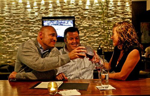 Cruz Del Costillo, left, Mike Adam and Cristina Walkins toast in the bar area of Root 246 in Solvang.