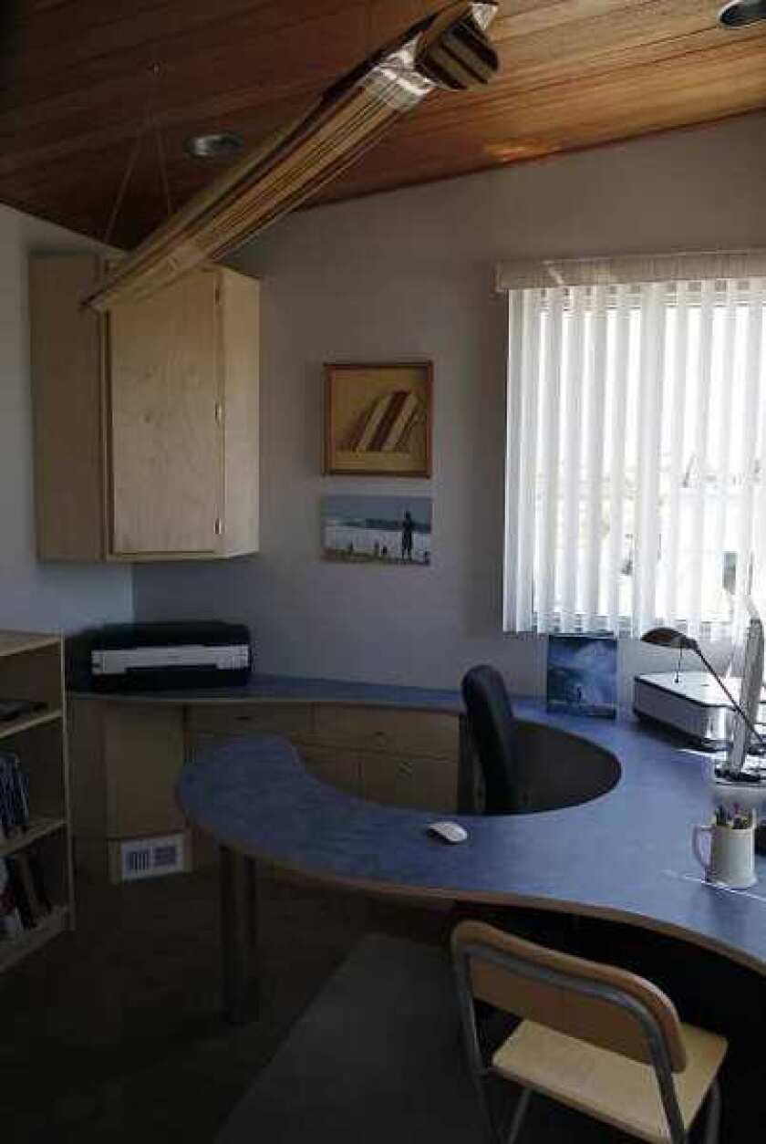 Newport Beach resident Mike Bless, a professional wood worker and craftsman, designed and built his office space to model a lifeguard tower, including a desk replicating a wave. He can see the waves from his office space over looking the beach.