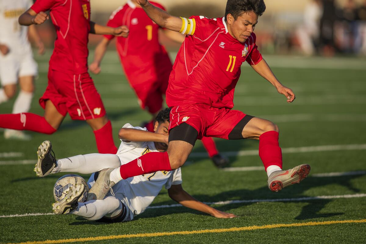 Ocean View's Juan Salazar (11) gets tripped up by Godinez's Diego Navarro (17) during a Golden West League match on Wednesday.