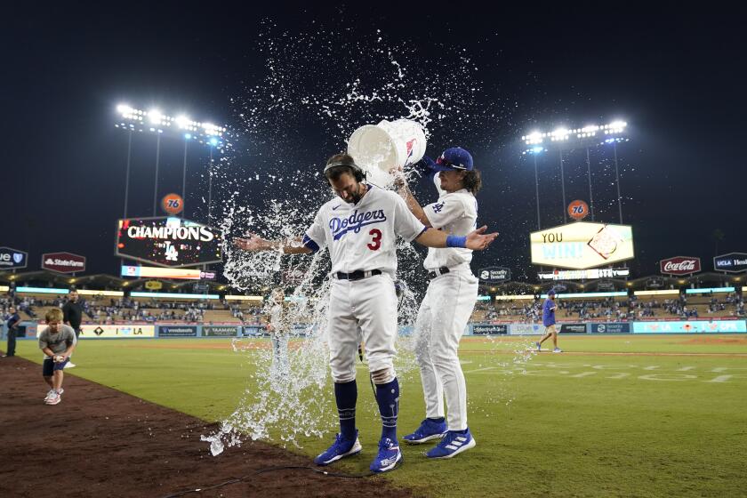 Los Angeles Dodgers' Chris Taylor (3) is doused with water by James Outman after hitting walk-off single to win a baseball game 3-2 against the San Francisco Giants in Los Angeles, Sunday, Sept. 24, 2023. Amed Rosario scored. (AP Photo/Ashley Landis)