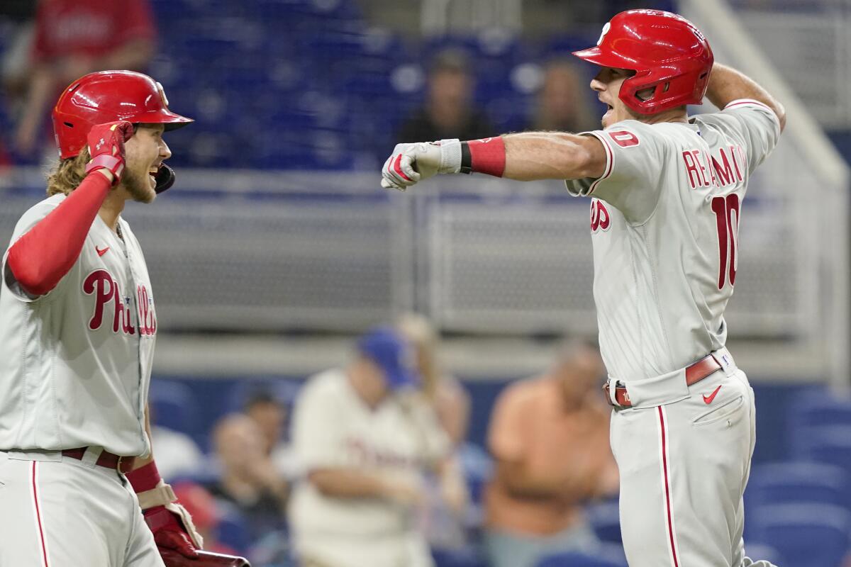 Philadelphia Phillies' J.T. Realmuto (10) celebrates with Alec Bohm after scoring on a solo home run during the sixth inning of a baseball game against the Miami Marlins, Wednesday, Sept. 14, 2022, in Miami. (AP Photo/Lynne Sladky)