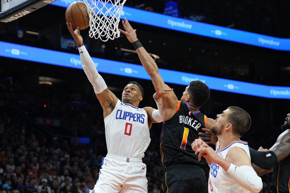 Clippers guard Russell Westbrook elevates above Suns guard Devin Booker for a layup.