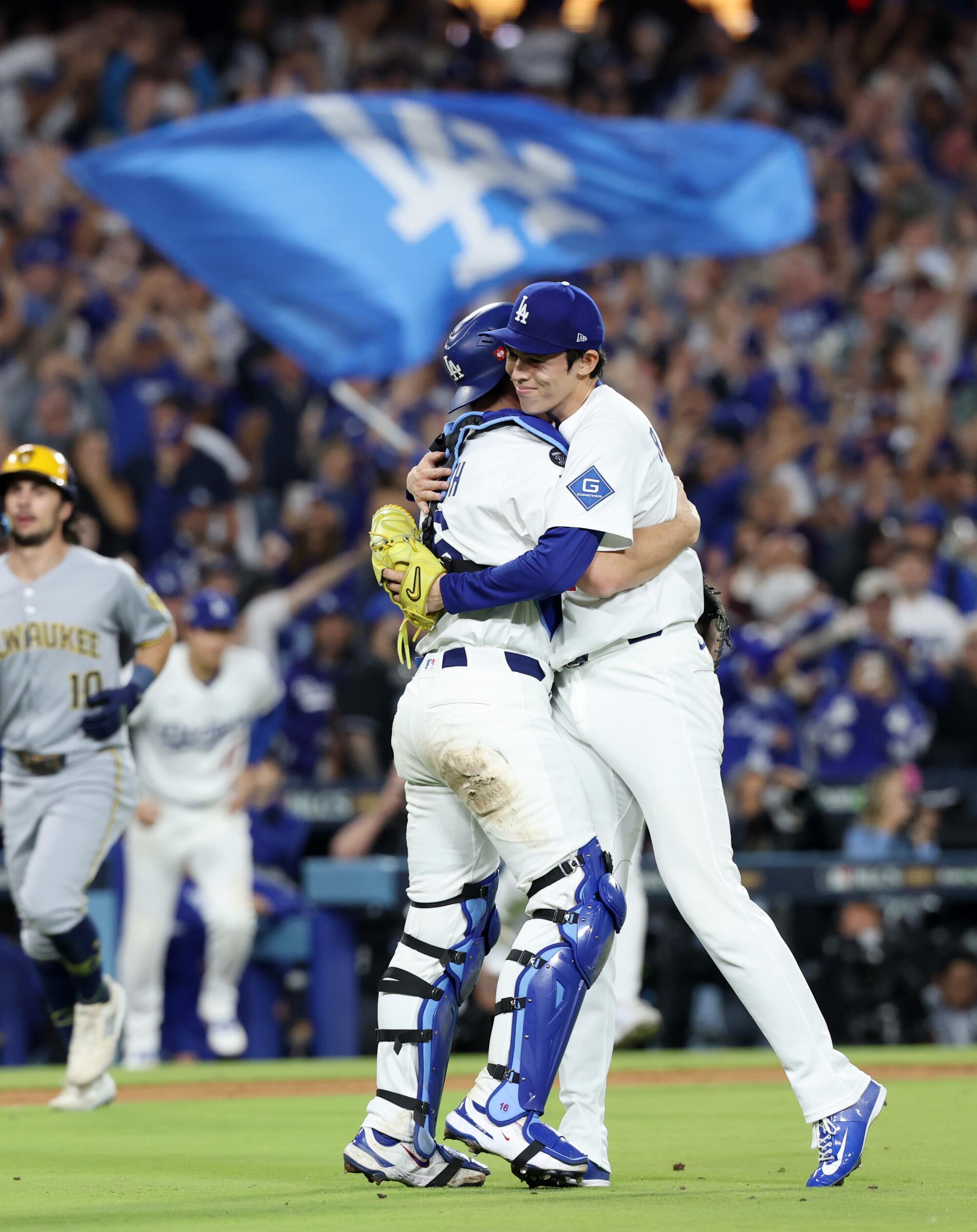O apanhador dos Dodgers, Will Smith, abraça o arremessador Roki Sasaki após o jogo 4 do NLCS na sexta-feira.