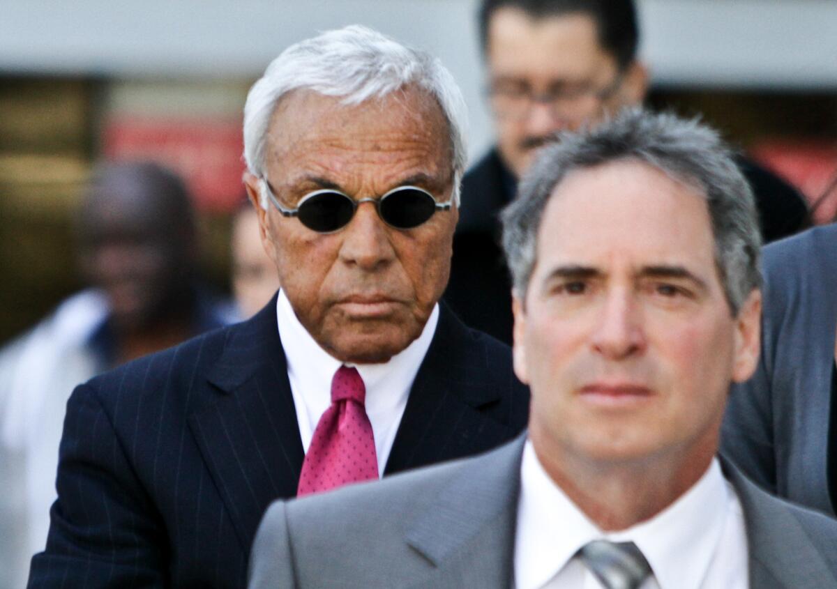 Former Countrywide chief executive Angelo Mozilo, in dark glasses, emerges from Superior Court in Van Nuys in 2010.