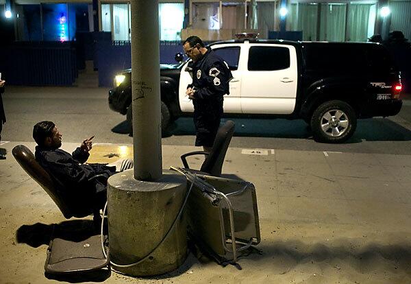 Sgt. Dan Gonzalez of the Los Angeles Police Department questions a man on Ocean Front Walk in Venice on a recent night. In response to residents' and merchants' complaints, the LAPD has been enforcing a curfew that bars people from sleeping along the beach overnight.